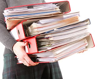 A woman confidently holds a stack of documents - Coren Law Group P.C.